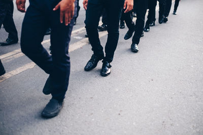 Low section of people walking on road