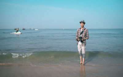 Man standing on beach against sky