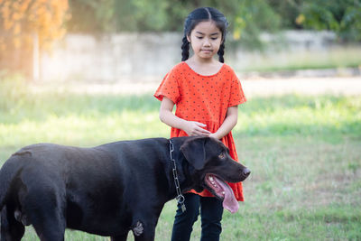 Cute boy with dog on field