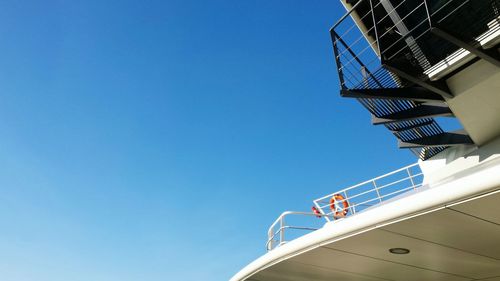 Low angle view of boats against clear blue sky