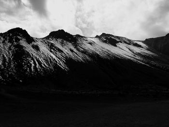 Scenic view of mountains against cloudy sky