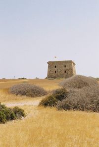 Building on field against clear sky