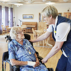 Nurse in care home talking with senior woman