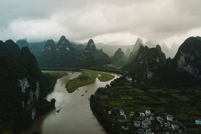 Scenic view of river and mountains against sky