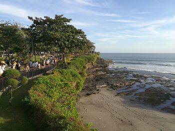 Group of people on beach against sky