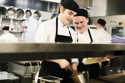 Young male chefs cooking together in commercial kitchen
