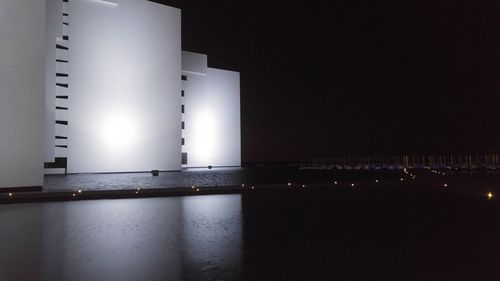 Illuminated water against sky at night