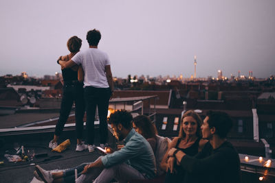 Rear view of man and woman sitting against sky