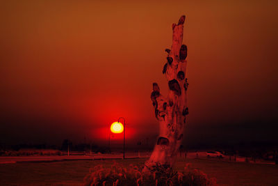 Scenic view of illuminated field against sky at sunset