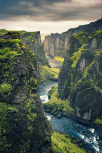 High angle view of river amidst rocky mountains against cloudy sky