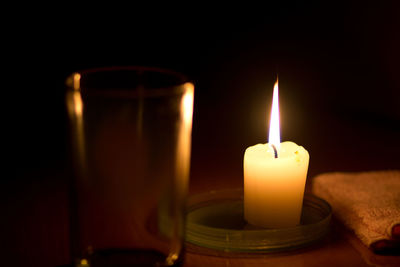 Close-up of lit candles in darkroom