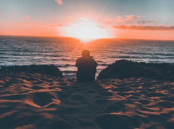 Rear view of man on beach during sunset