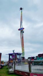 Low angle view of crane against cloudy sky