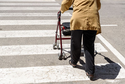 Low section of man walking on road