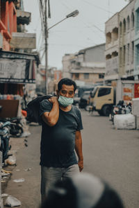 Young man wearing sunglasses standing on street in city