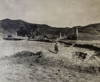 People on field against mountain range