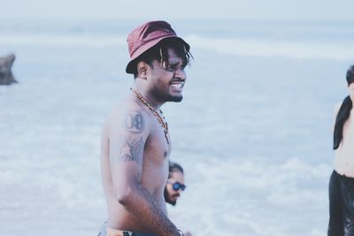 Portrait of smiling young man standing at beach