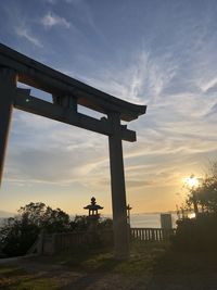 Built structure on field against sky during sunset