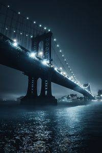 Low angle view of bridge over river at night