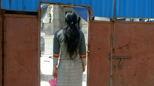 Rear view of woman entering gate