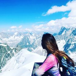 Side view of woman standing against snowcapped mountains