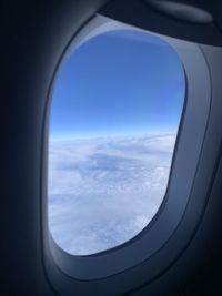 View of cloudy sky seen through airplane window