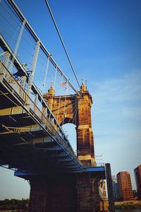 Low angle view of bridge and buildings against sky