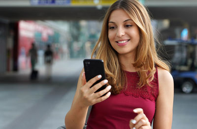 Smiling young woman using mobile phone