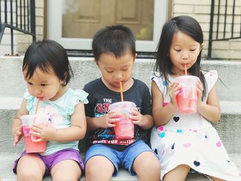 Friends drinking while sitting outdoors