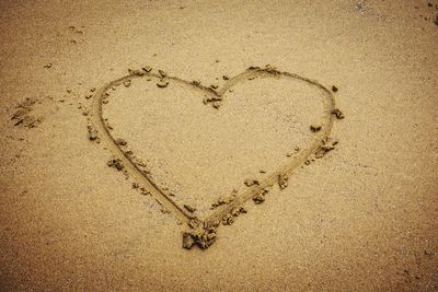 High angle view of heart shape made on sand