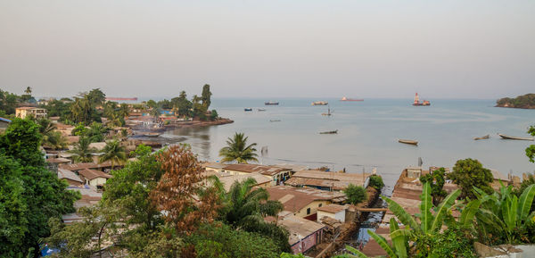 Scenic view of town by sea against clear sky