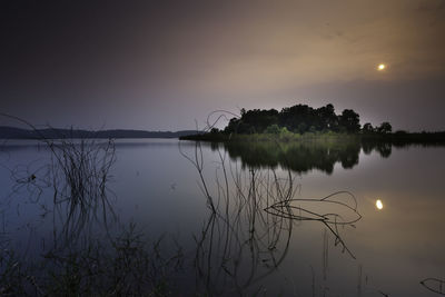 Scenic view of lake against sky at sunset