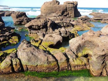 Scenic view of rock formation by sea against sky