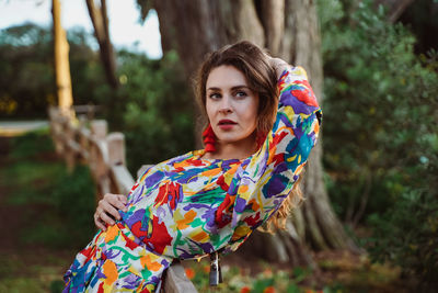 Woman with head in hands leaning on fence