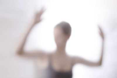 Defocused image of woman dancing against white background