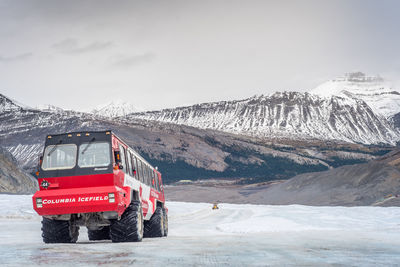 Car on snowcapped mountain against sky