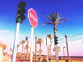 Low angle view of road sign against blue sky