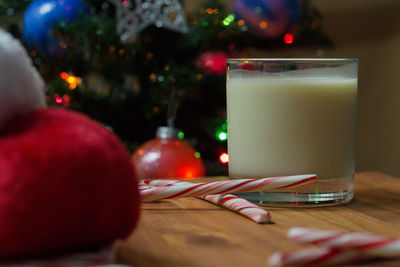 Close-up of drink by candy canes in glass on table