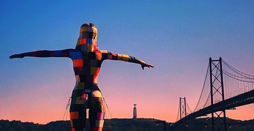 Low angle view of silhouette cranes against sky during sunset