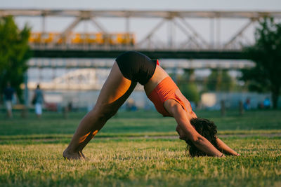 Woman exercising on grassy field