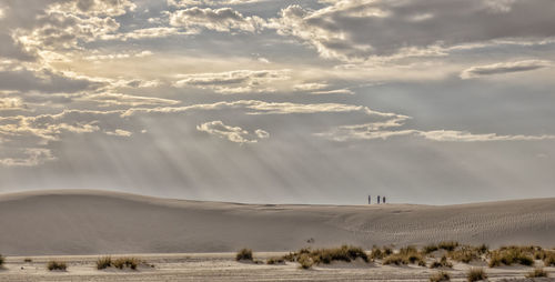 View of desert against cloudy sky