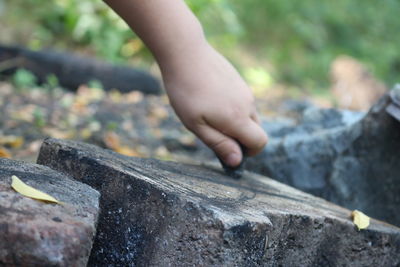 Cropped hand rubbing rock