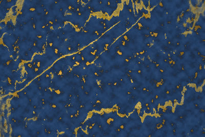 Mineral gold in dark blue marble surface of cave for interior wallpaper and background