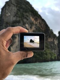 Man photographing with mobile phone in sea
