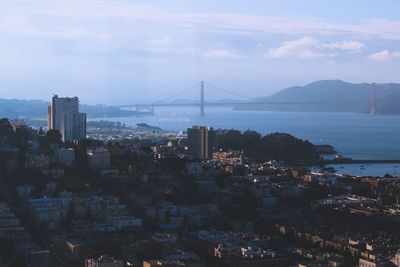 Cityscape by sea against sky