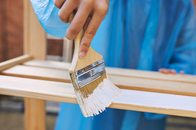 Midsection of woman painting furniture