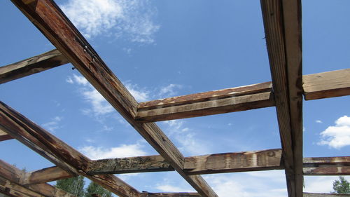 Low angle view of old wooden structure against blue sky