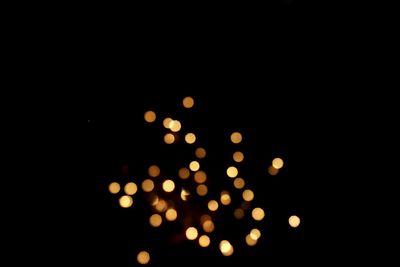 Defocused lights against sky at night