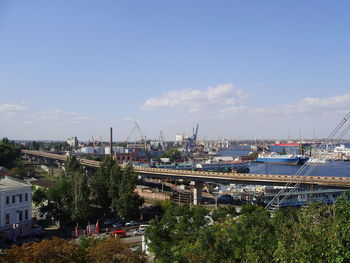 Boats moored at harbor against sky in city