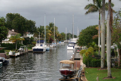 Boat moored in calm water against cloudy sky